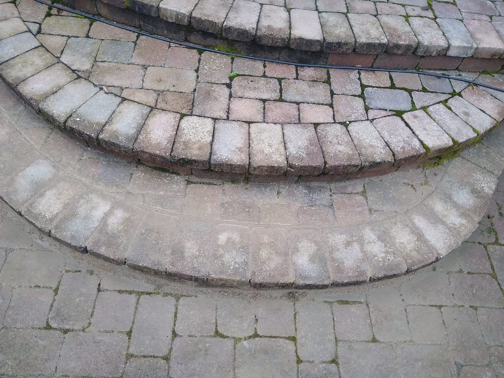 A close up of a brick walkway with steps.