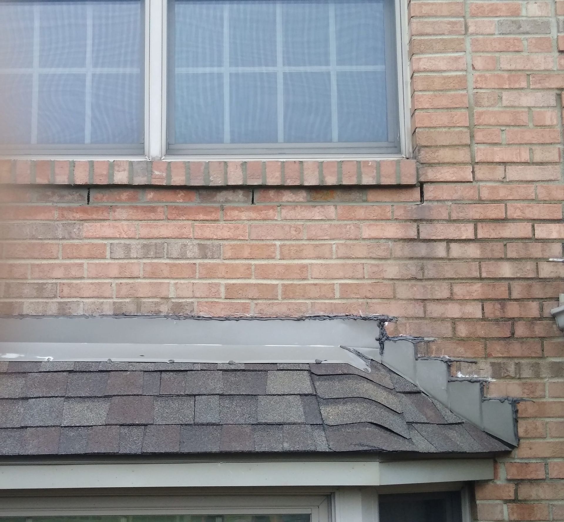 A brick building with a window and a roof