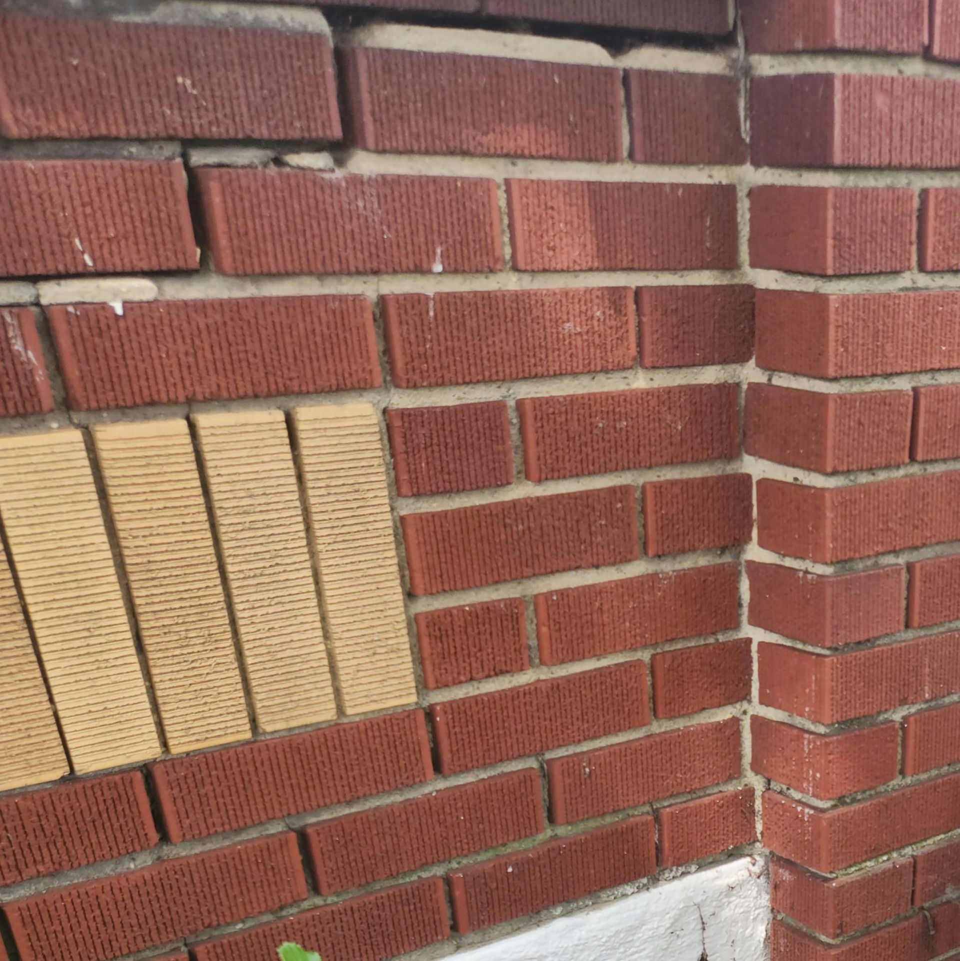 A brick wall with a yellow brick in the middle