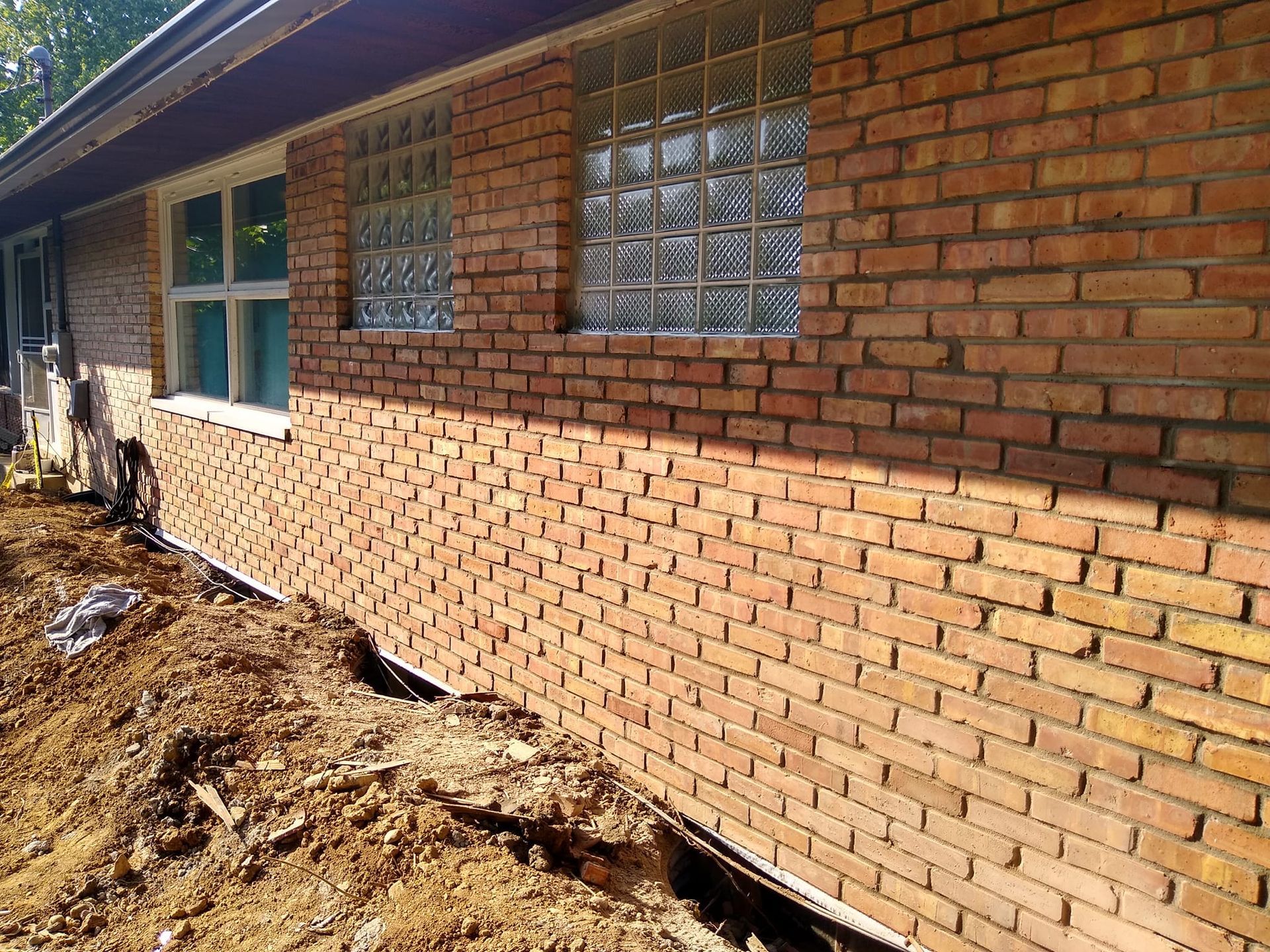 A brick wall of a house with a window.