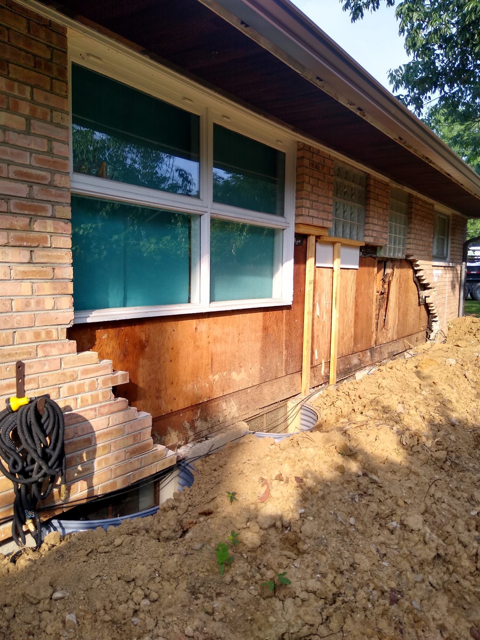 A brick house with a lot of dirt in front of it.