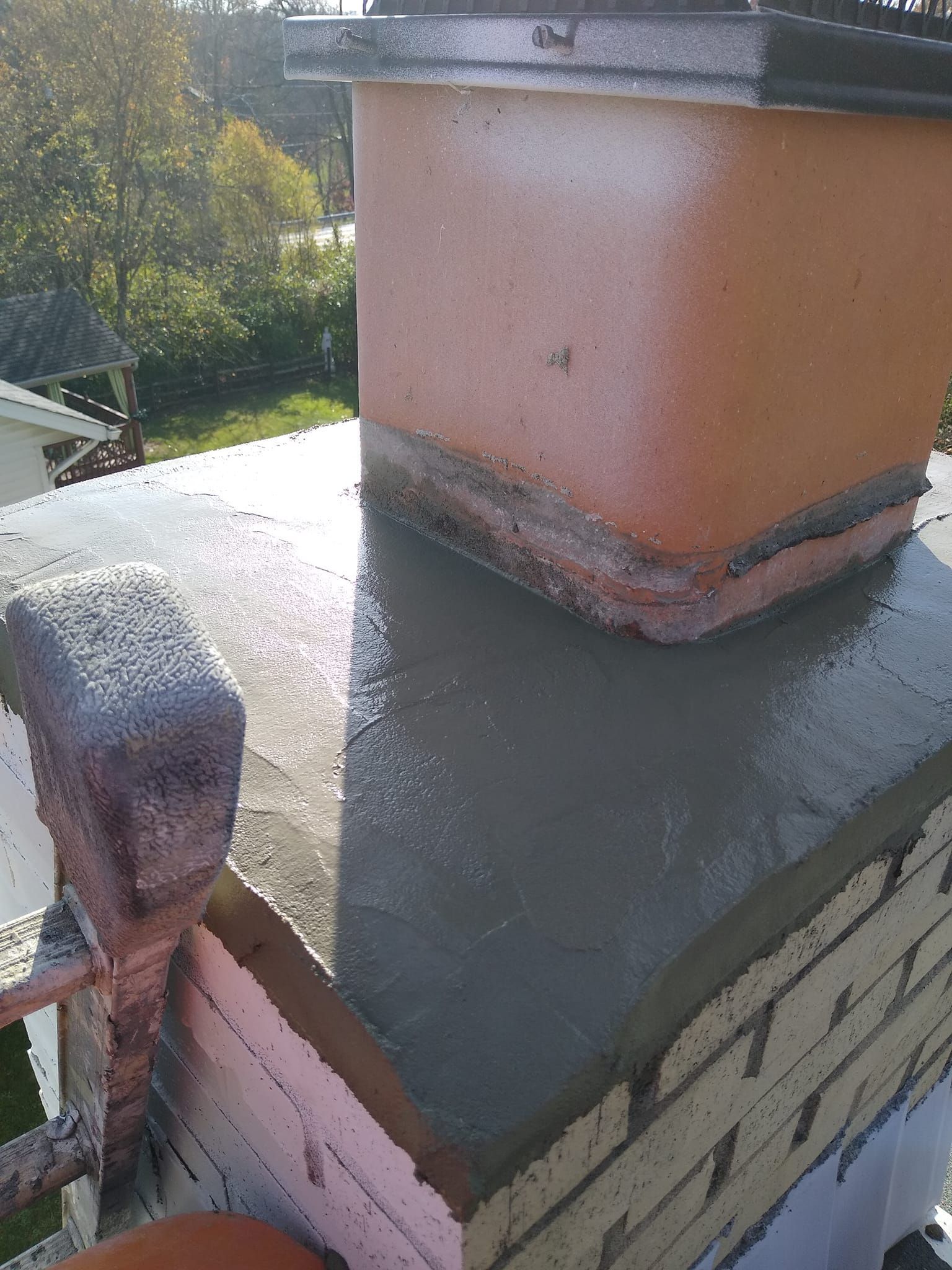 A chimney is being built on top of a brick building.