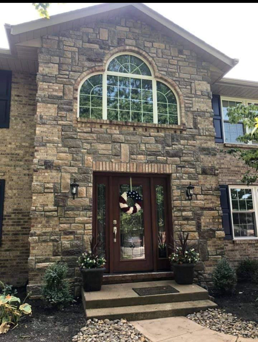 A large stone house with a wooden door and a large window.