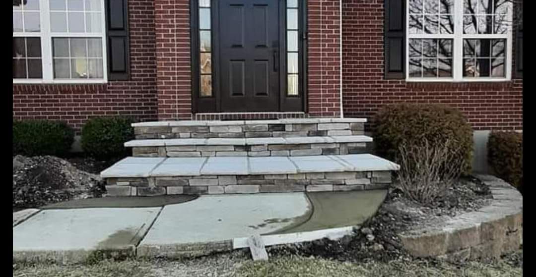 A brick house with a stone walkway leading to the front door.