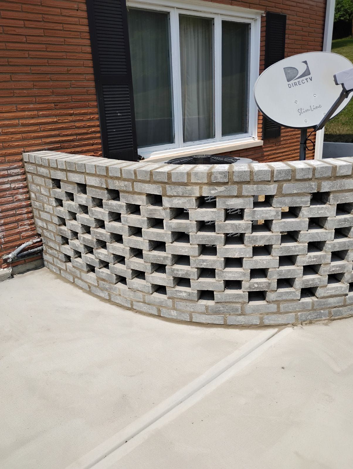 A brick wall with a satellite dish on top of it