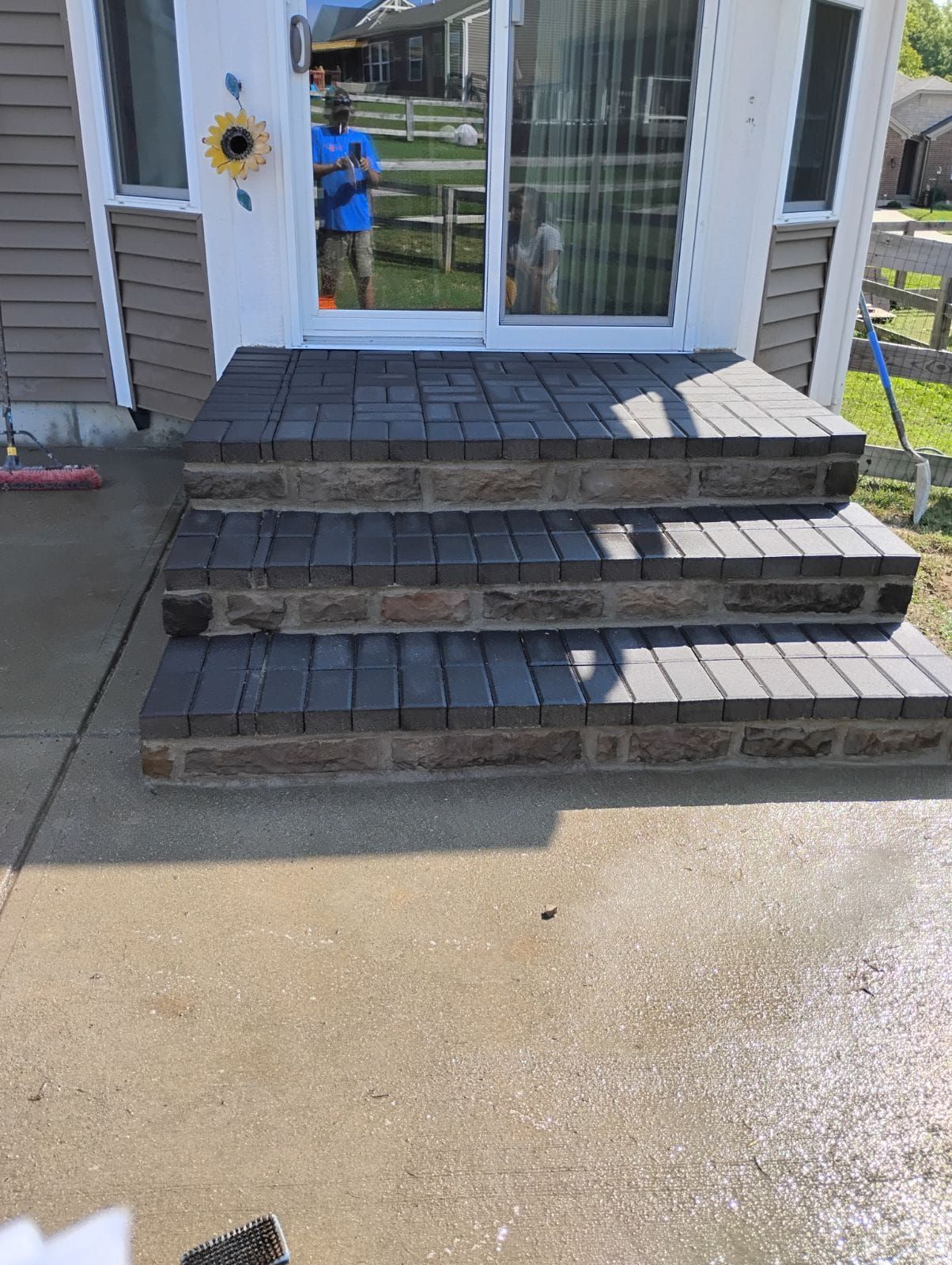 A man is standing in front of a house with stairs leading up to it.
