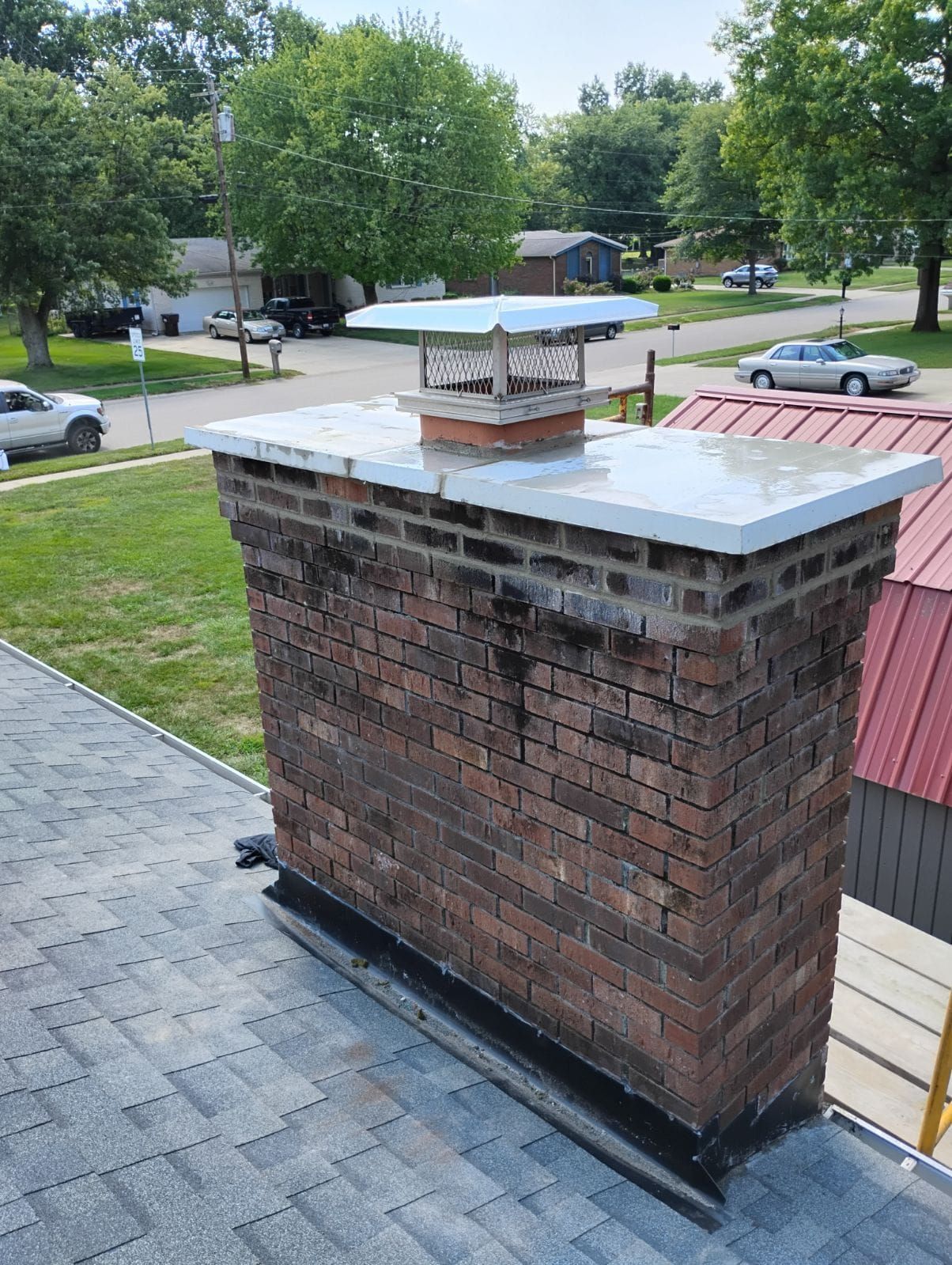 A brick chimney is sitting on top of a roof.