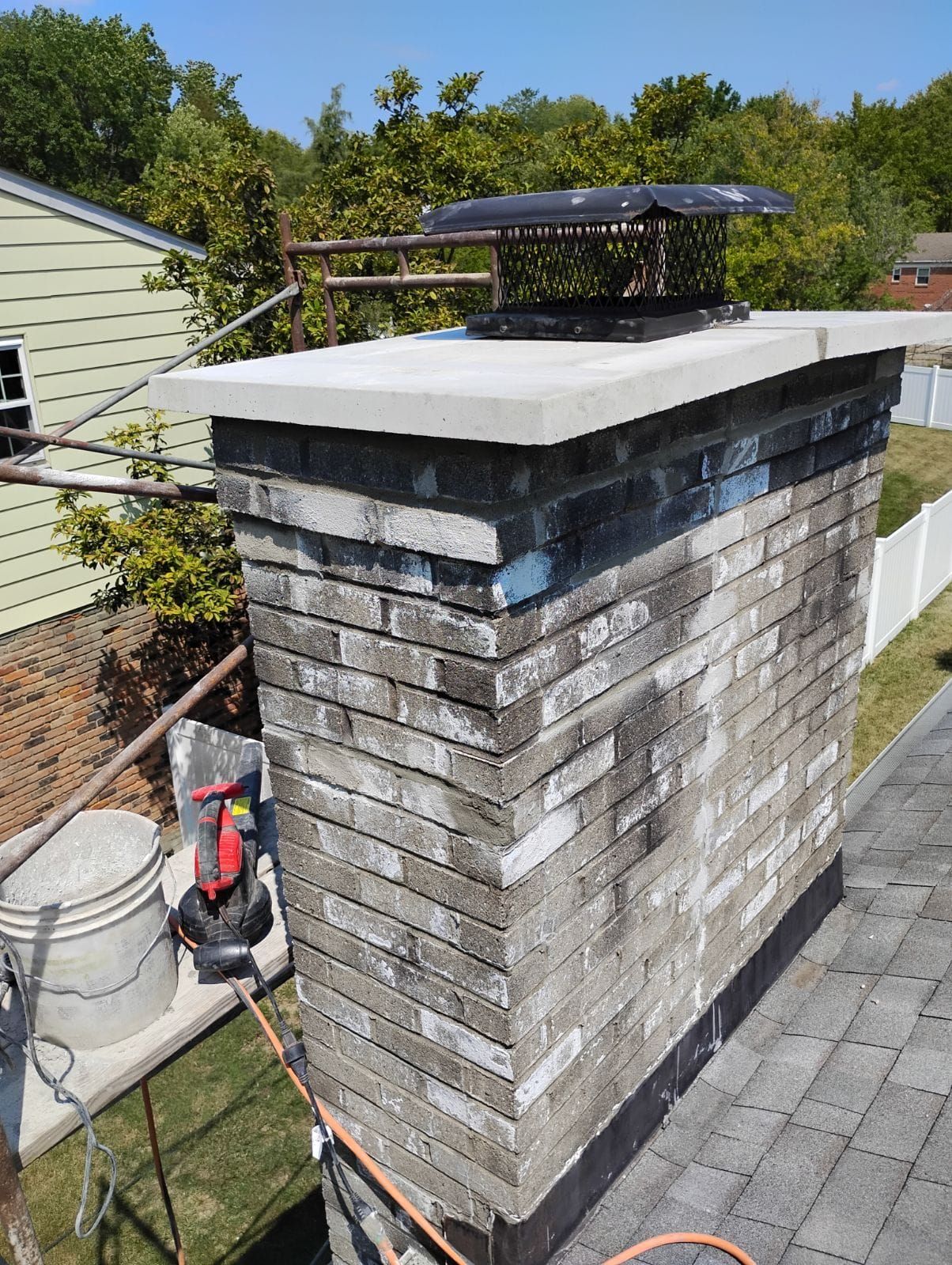 A brick chimney is sitting on top of a brick roof.