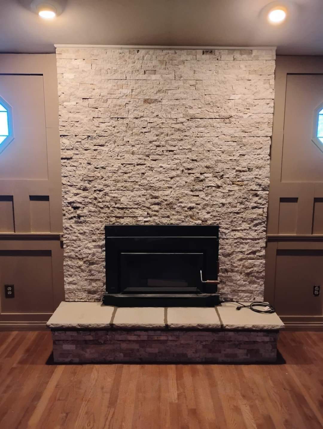 A fireplace in a living room with a stone wall