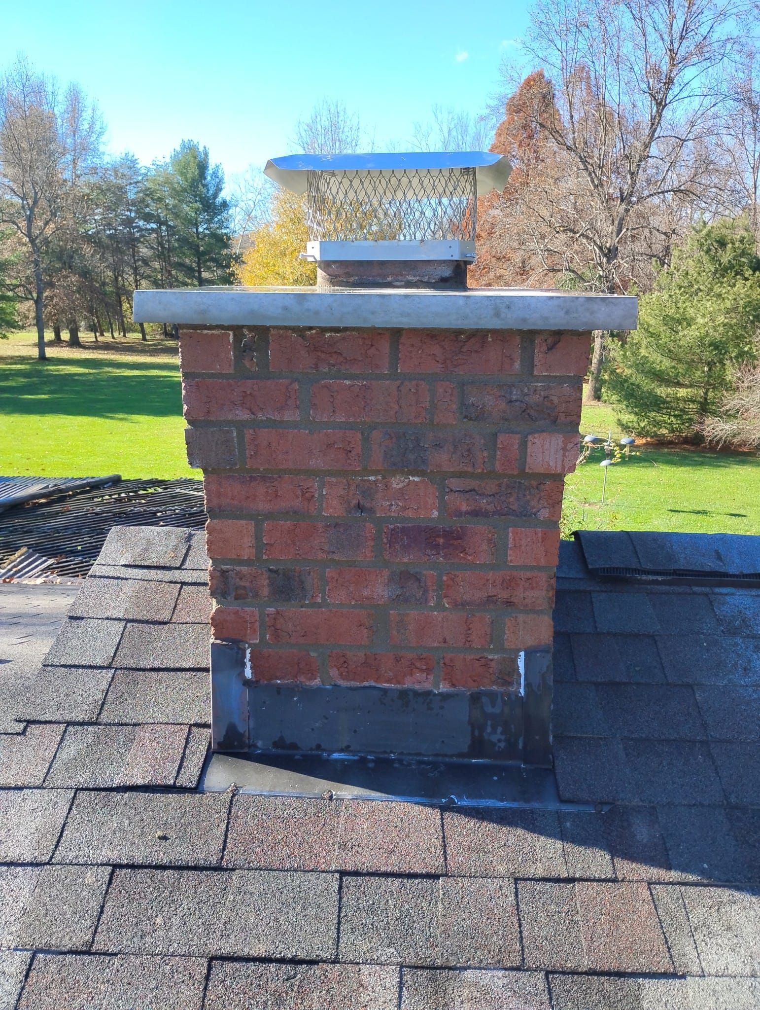 A brick chimney is sitting on top of a roof.