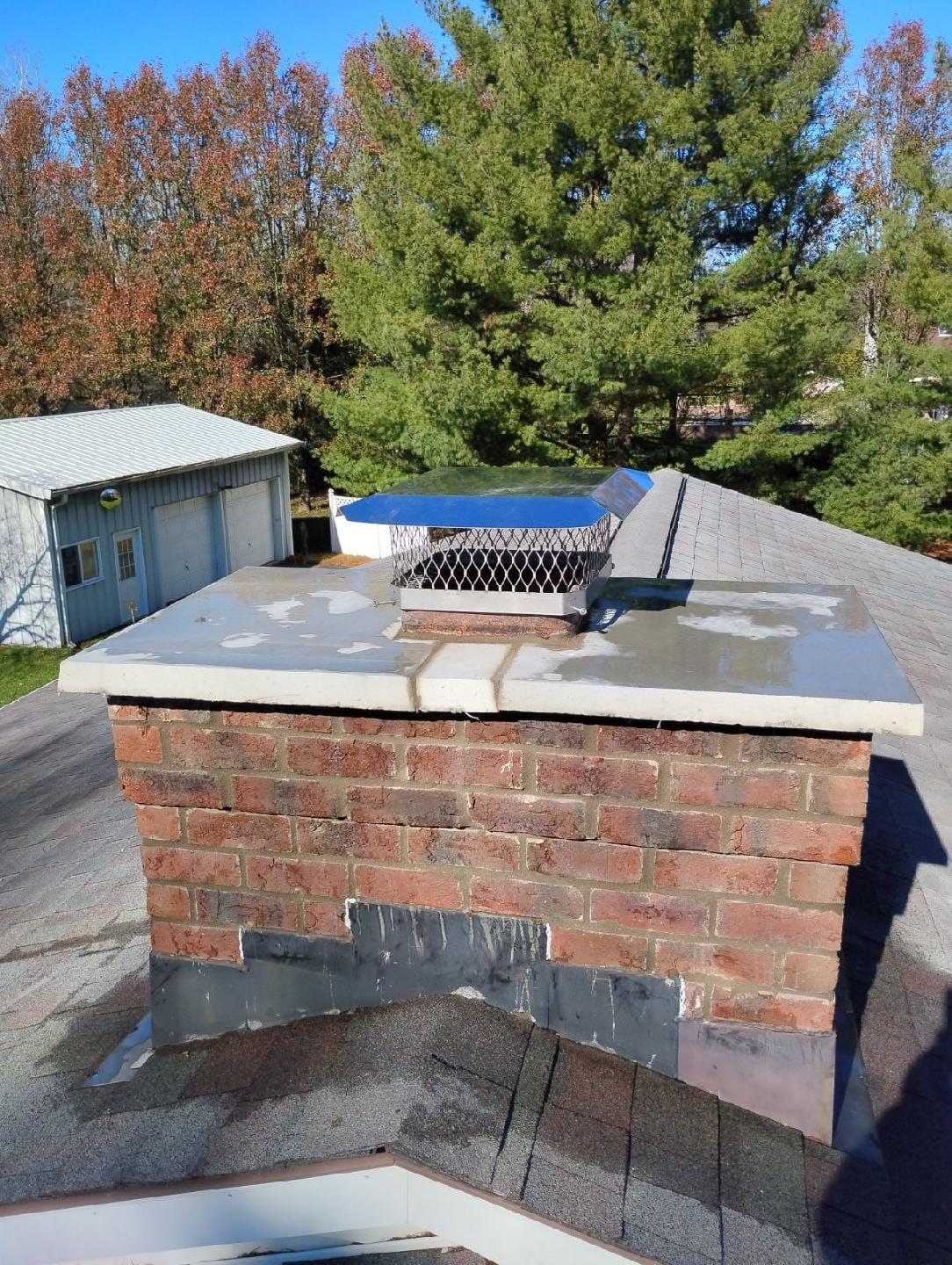 A brick chimney is sitting on top of a roof.