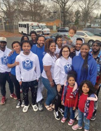 A group of people are posing for a picture in a parking lot.