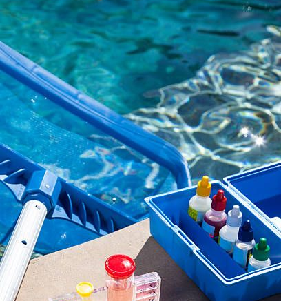 Close-up of a blue swimming pool vacuum head submerged in clear, shimmering pool water.