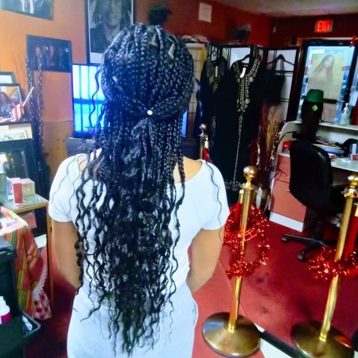 A woman with braids in her hair is standing in a room