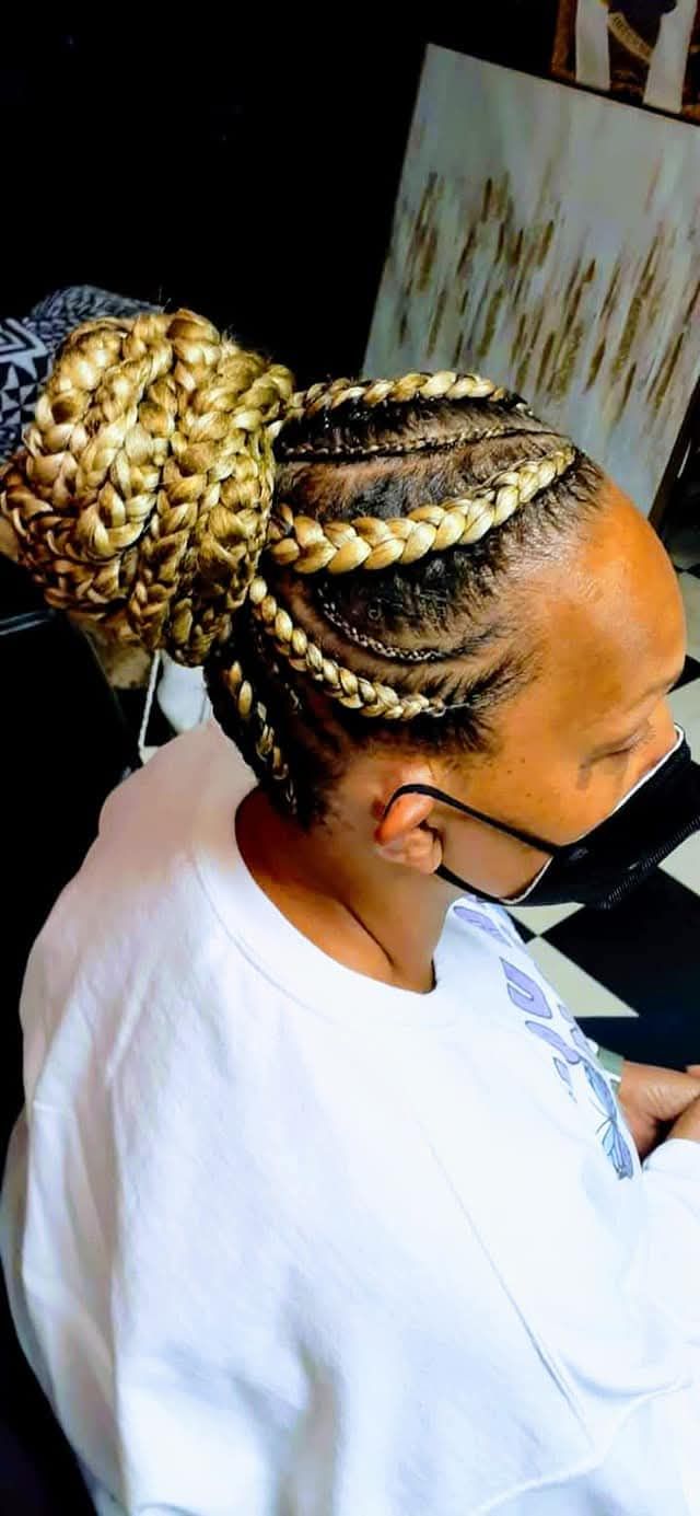 A woman with braids in a bun wearing a mask.