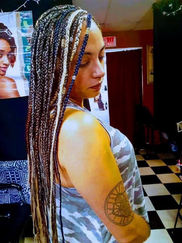 A woman with braids and a tattoo on her arm