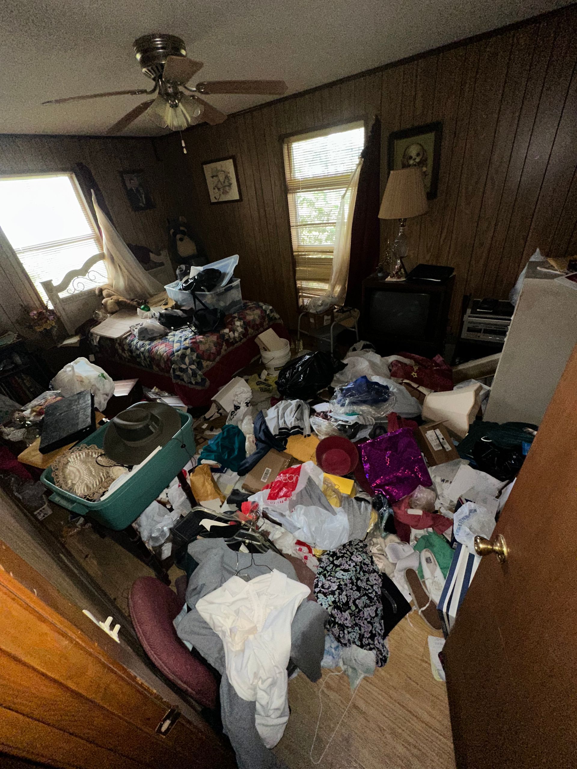A room filled with lots of clothes and a ceiling fan.