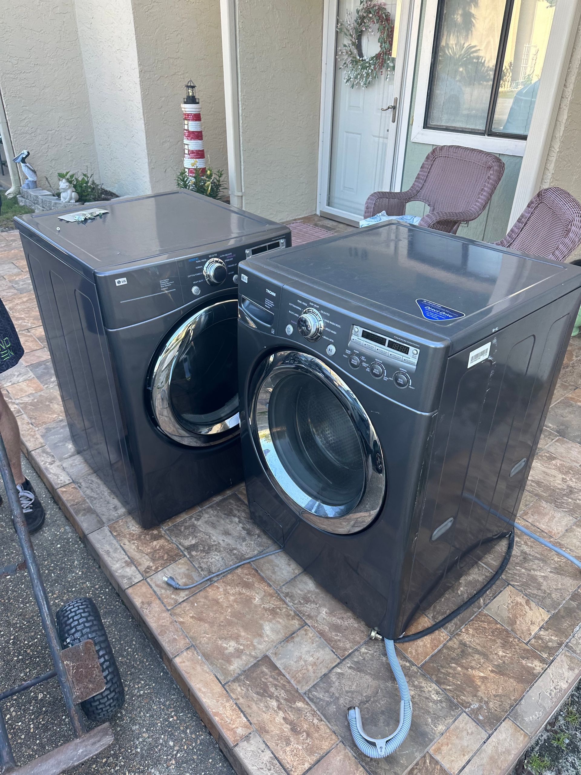 Two washing machines are sitting next to each other on a patio.