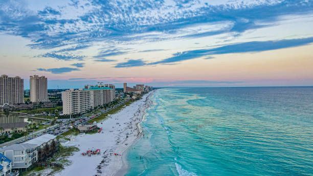 An aerial view of a beach with a city in the background.