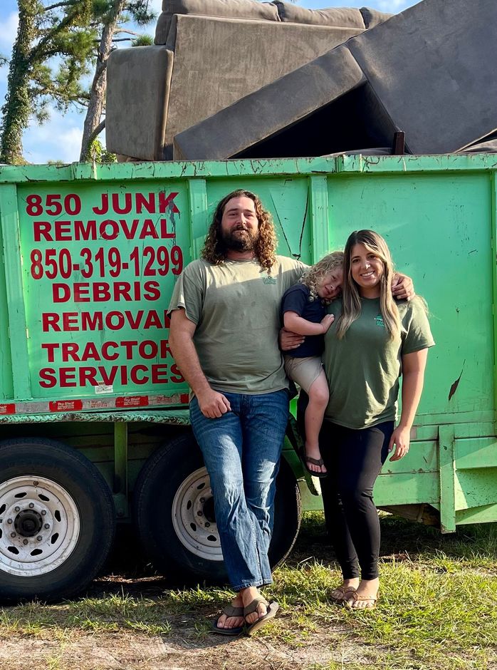 A man and a woman are standing in front of a dumpster.