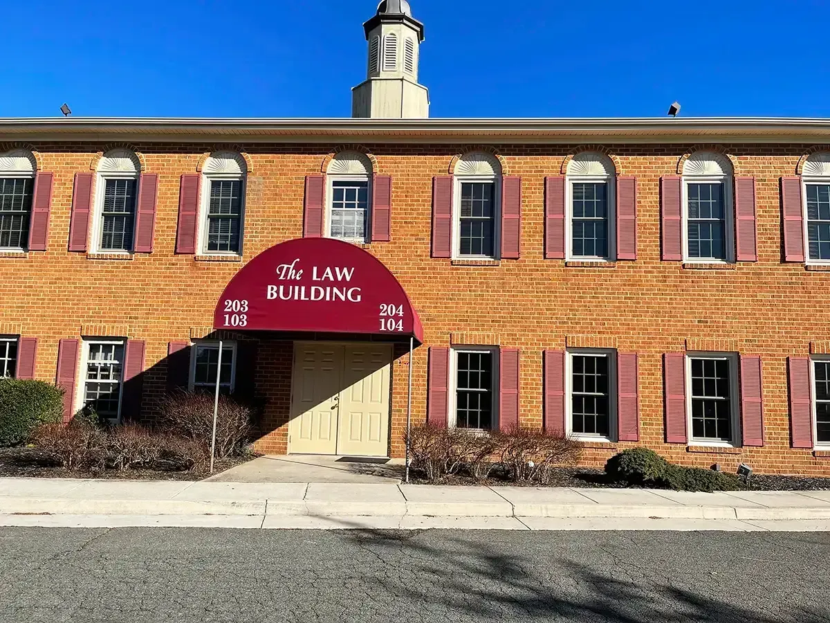A large brick building with a red awning over the entrance.