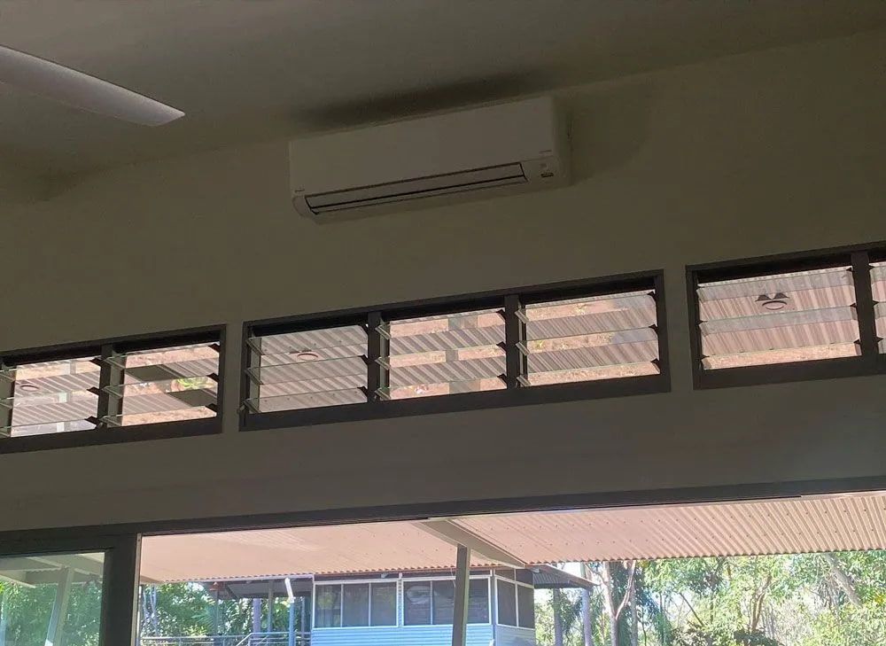 An Air Conditioning Unit Above a Row of Glass — Active Airconz in Darwin, NT