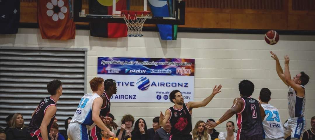 Volleyball players jump at the net during an indoor match in a gymnasium — Active Airconz in Winnellie, NT
