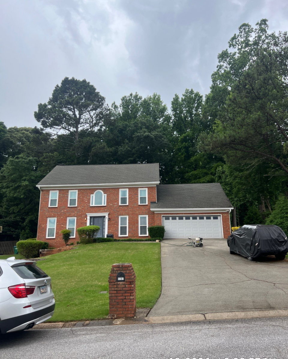 A brick house with a car parked in front of it