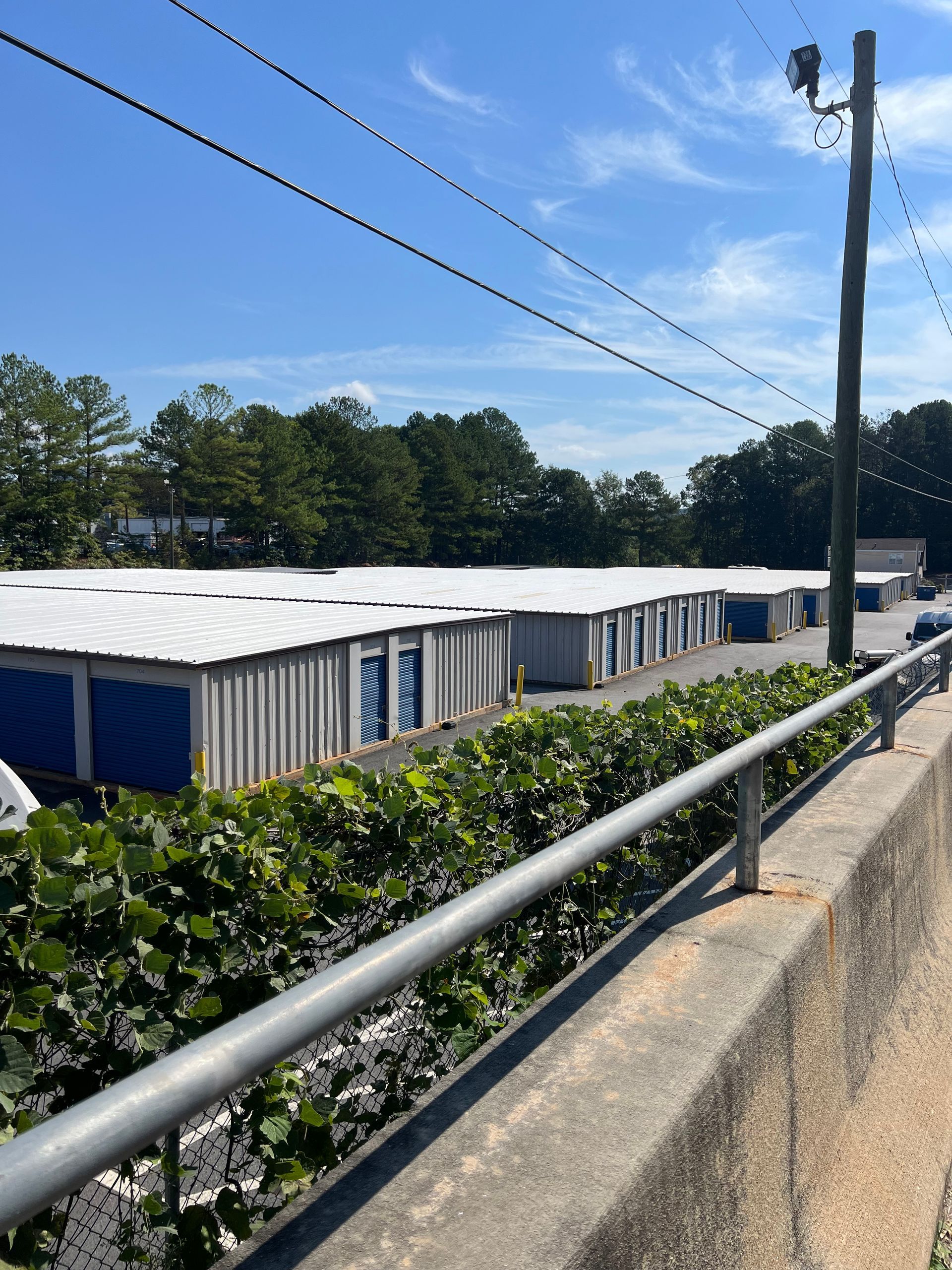 A row of storage units are lined up next to a railing