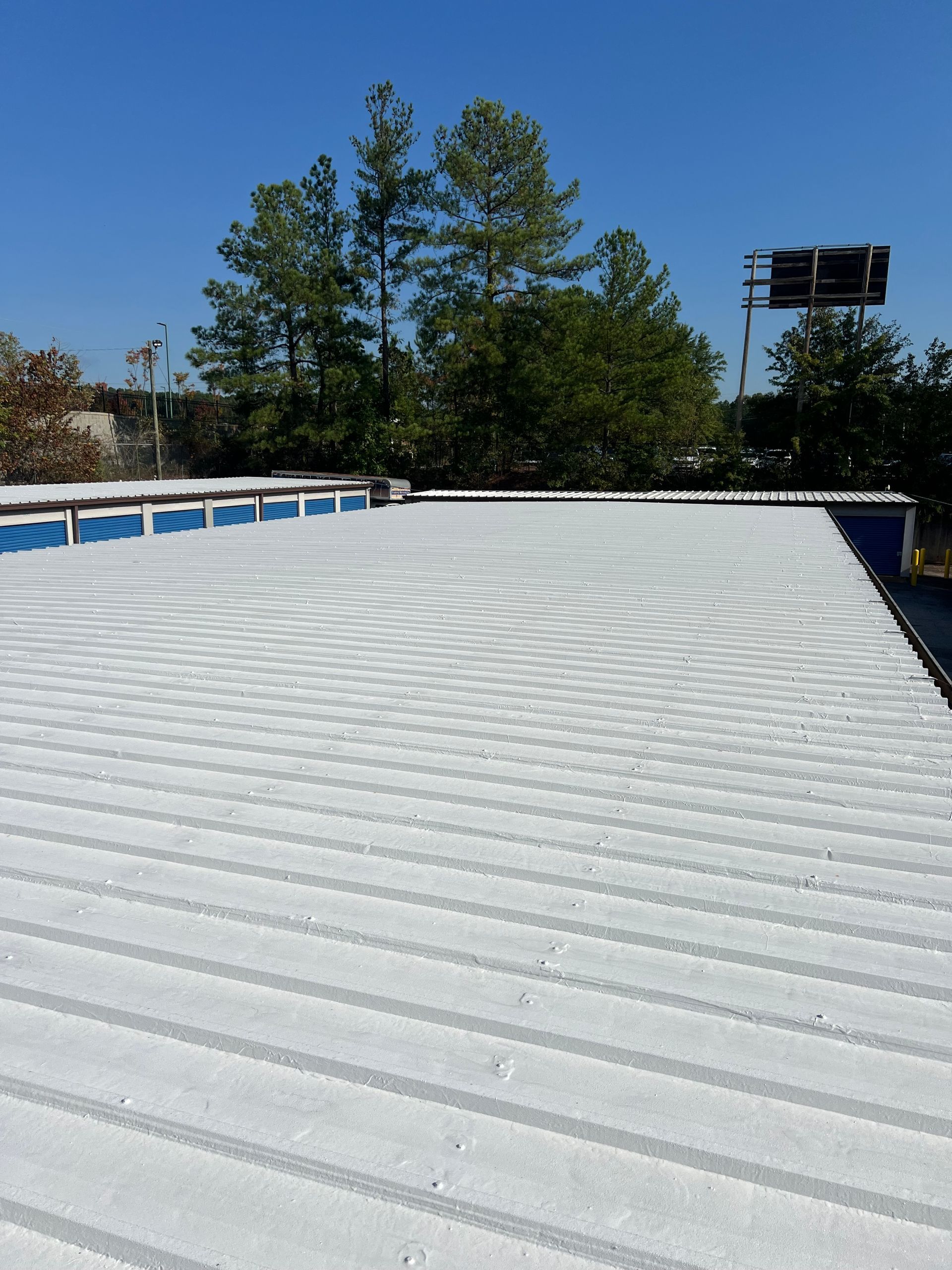 A large white roof with trees in the background