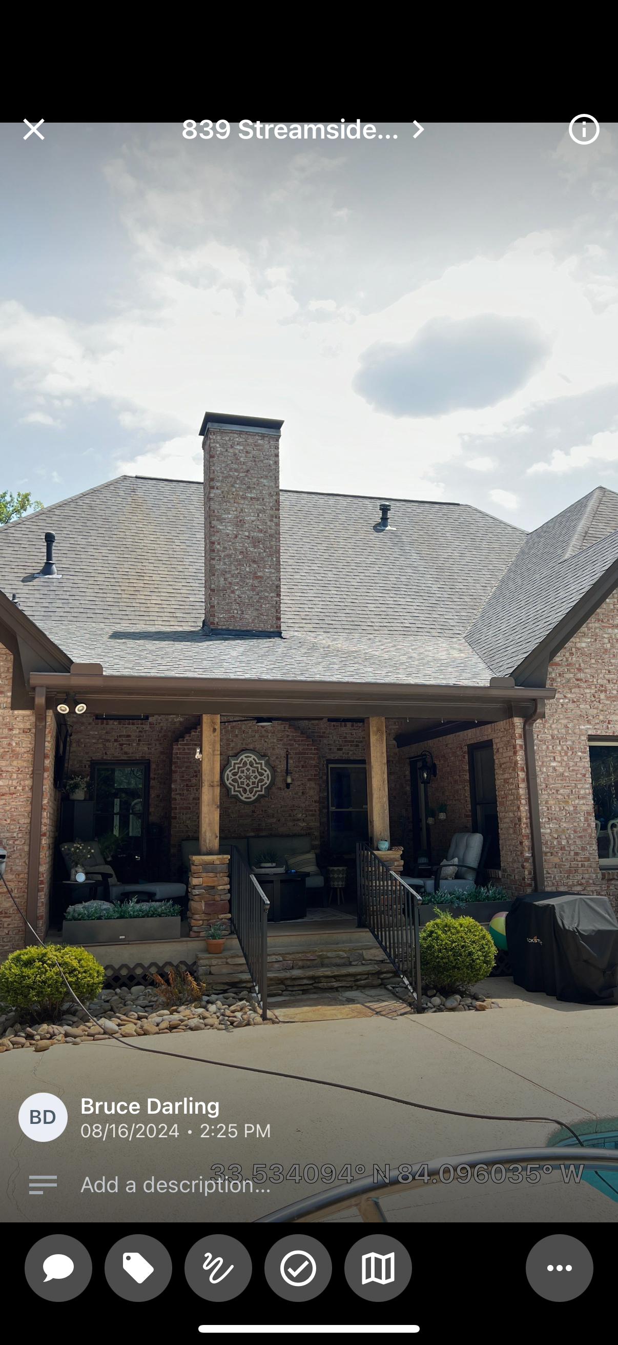 A brick house with a covered porch and a chimney on the roof.