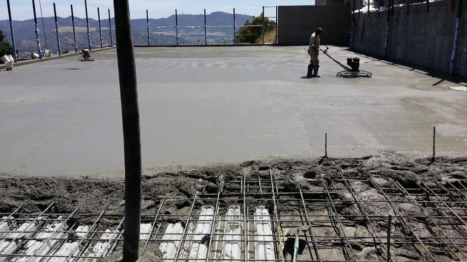 A Man Is Spreading Concrete on A Concrete Floor