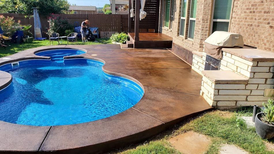 There Is a Large Swimming Pool in The Backyard of A House