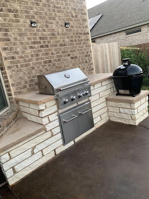 A Grill Is Sitting on Top of A Brick Counter Next to A Brick Wall