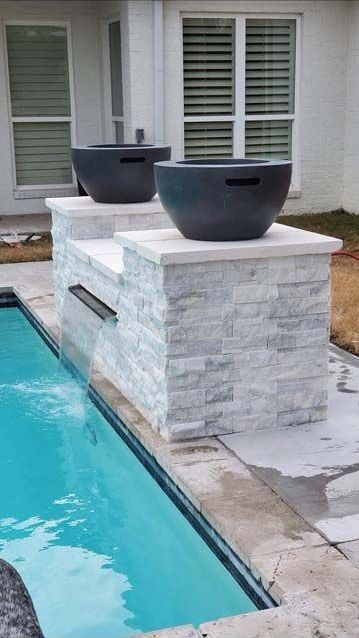 Two Bowls Are Sitting on Top of A Brick Wall Next to A Swimming Pool