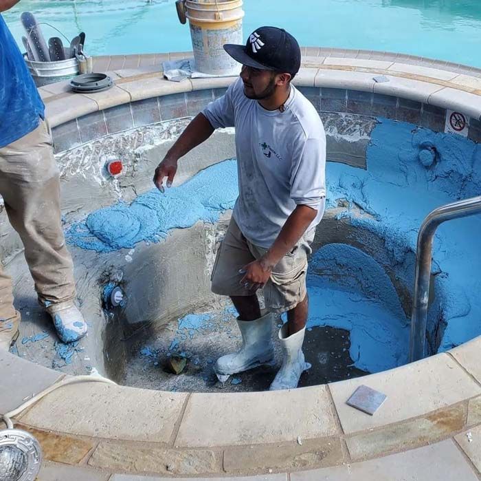A Man Wearing a Hat Fixing the Swimming Pool
