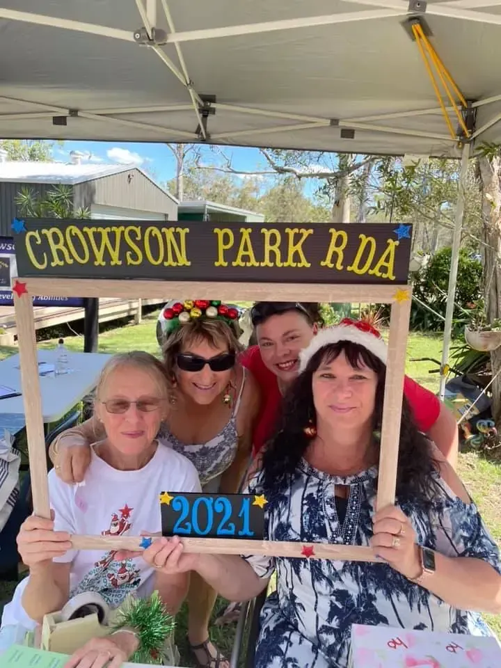 Group poses behind a frame labeled