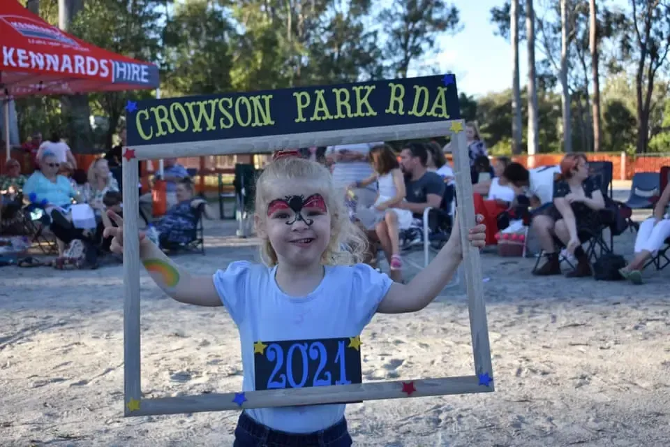 Child with butterfly face paint holds a