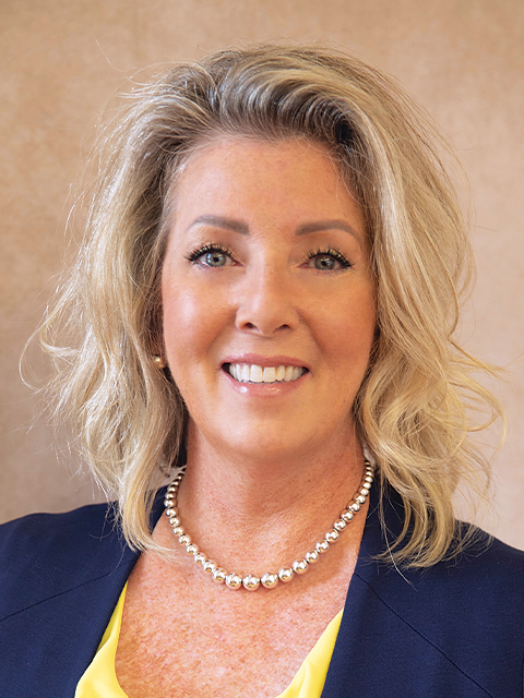 A man wearing glasses is sitting in front of a laptop computer.