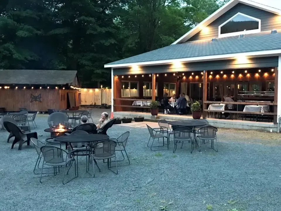 Exterior of a building with tables and chairs.