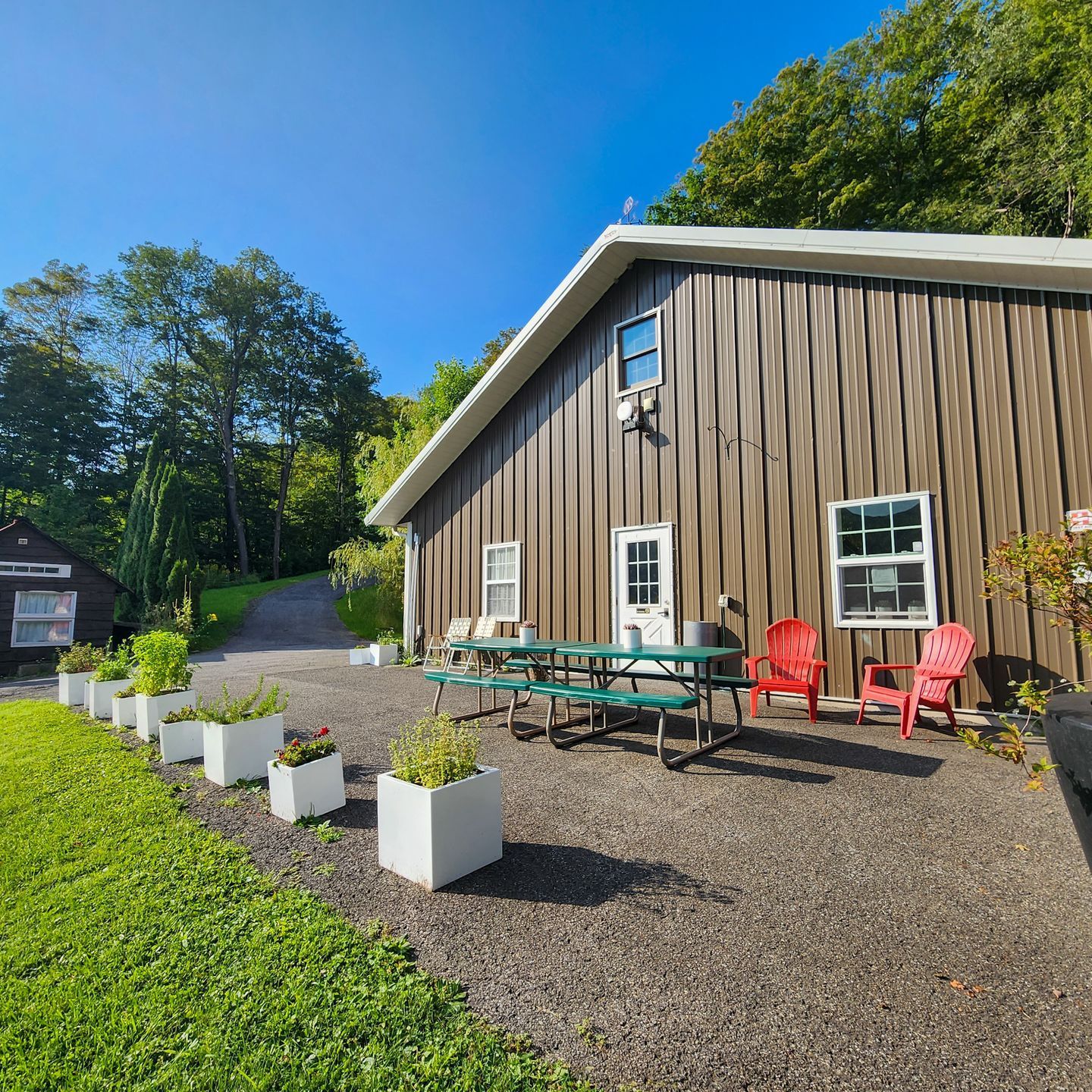 Exterior of one of Belleayre Lodge's cabins, showing red chairs and picnic table.
