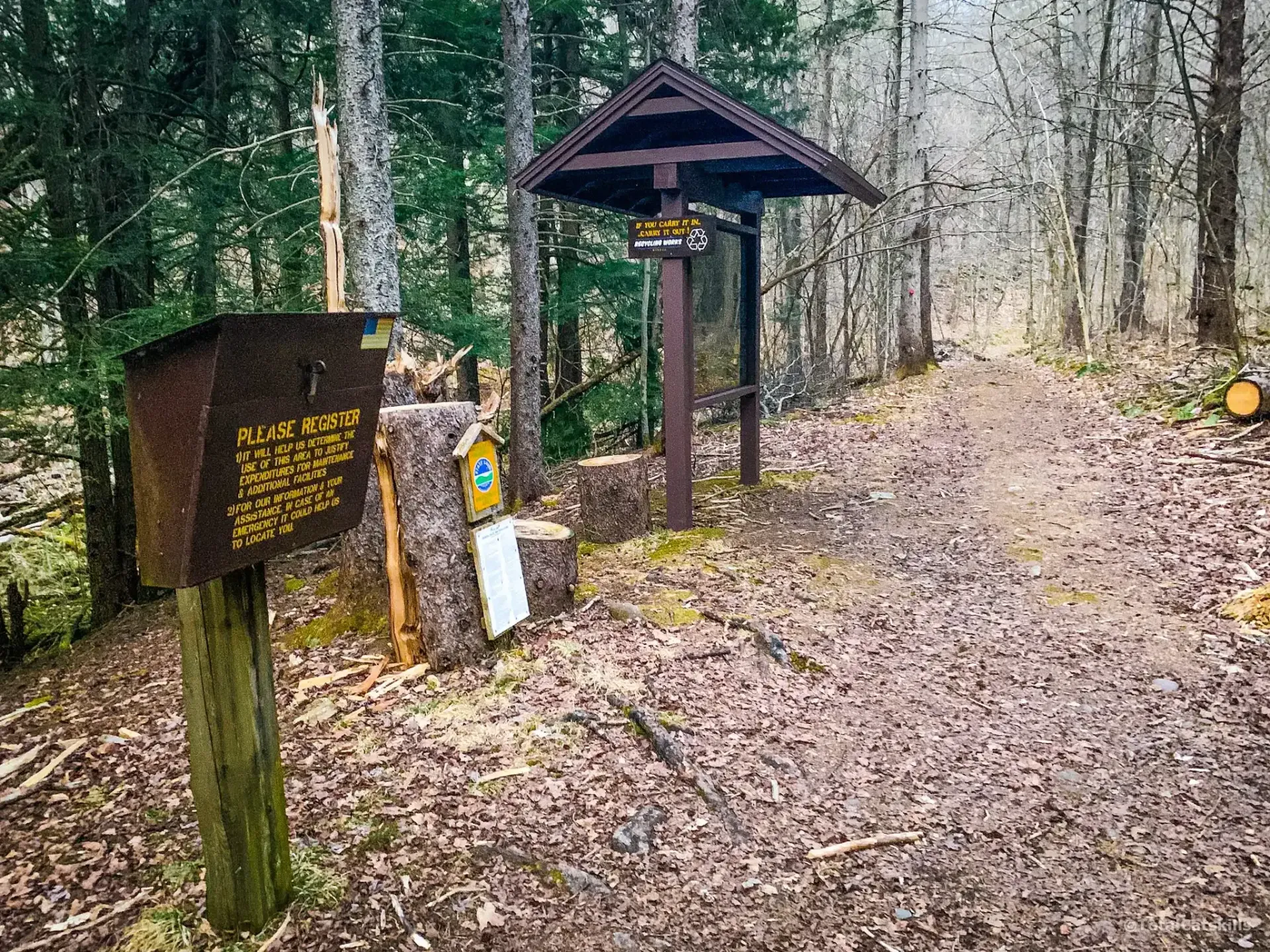 Color photo of wooden structures in the woods.