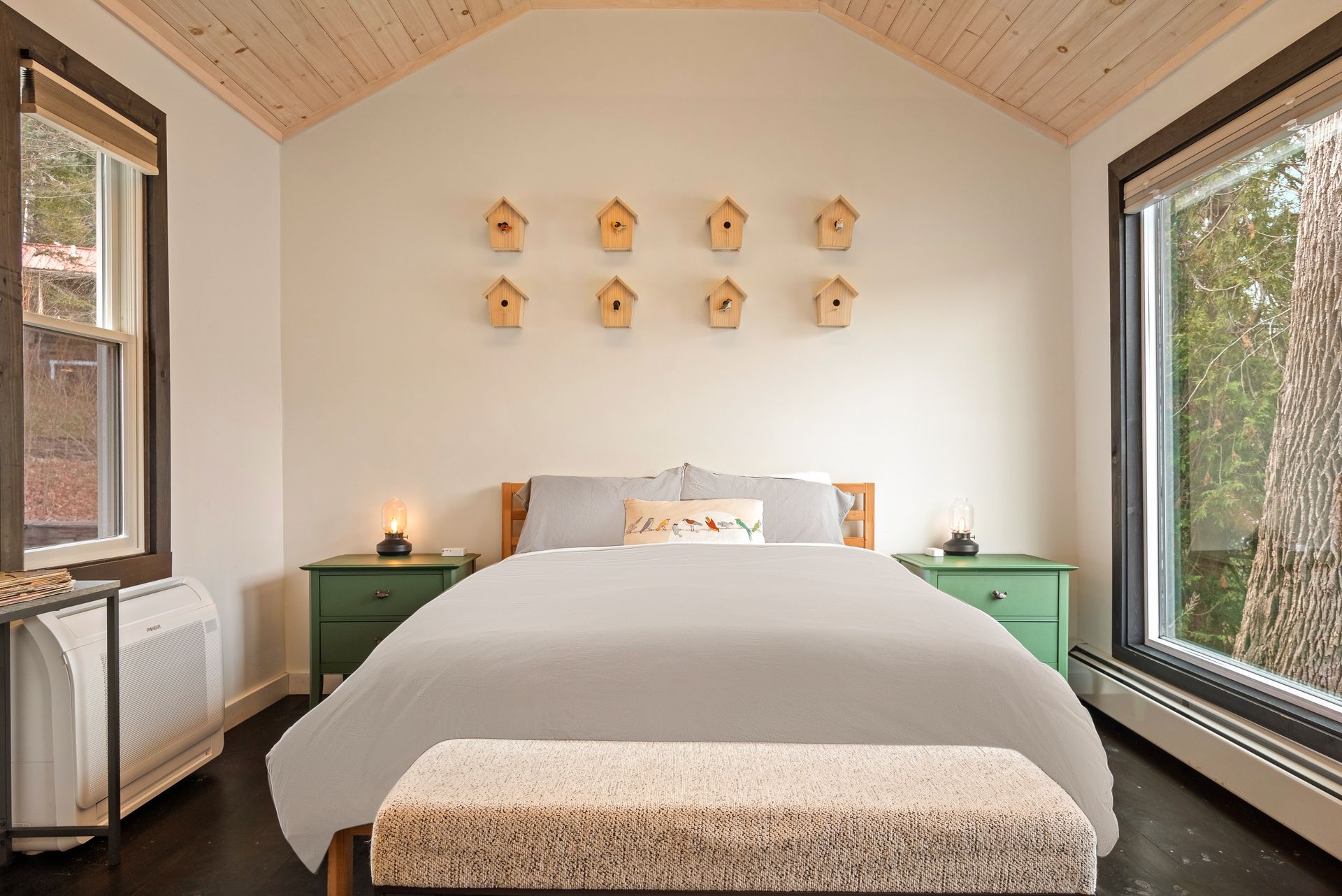 Inside shot of Belleayre Lodge Cabin 1, showing a cozily made bed and tasteful decor on the walls