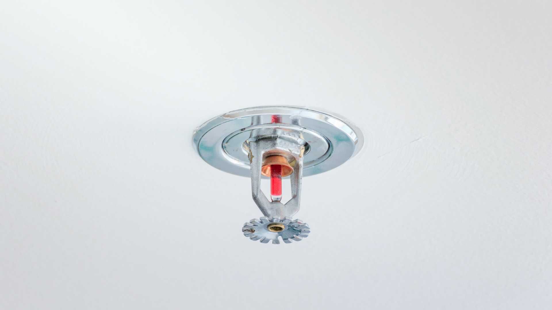 A fire sprinkler is hanging from the ceiling of a building.