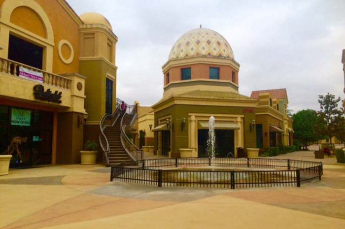 Fountain in plaza area for outdoor mall area. Stairs going up between buildings.