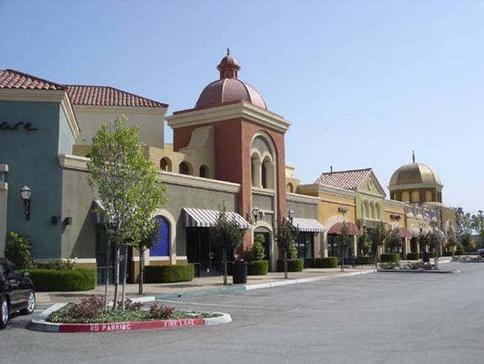 Exterior of retail and outdoor mall area with multi-colored stucco sides.