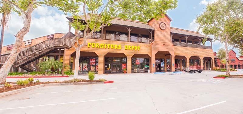Furniture Depot exterior. Row of retail stores with one pickup truck in parking lot.