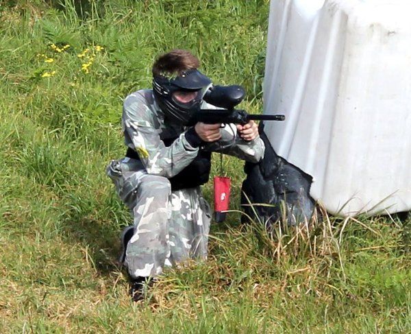 paintball player crouching in grass