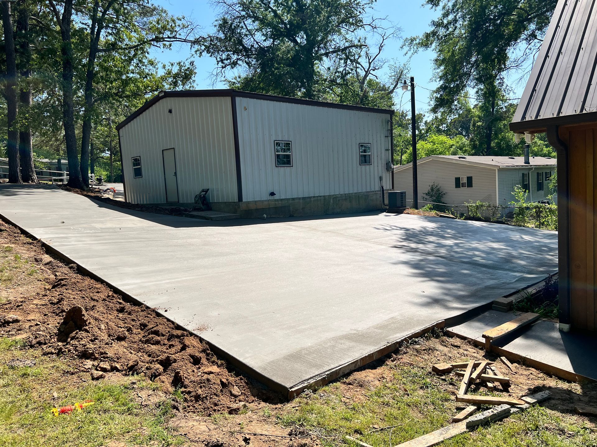 A concrete driveway is being built in front of a white building.