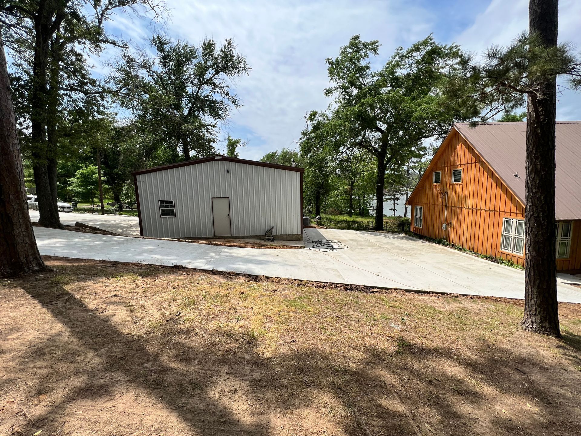 A large metal building is sitting in the middle of a lush green forest.